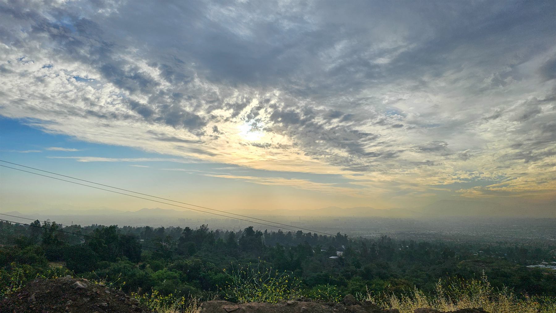 Atardecer con nubes sobre un valle, visto desde una colina
