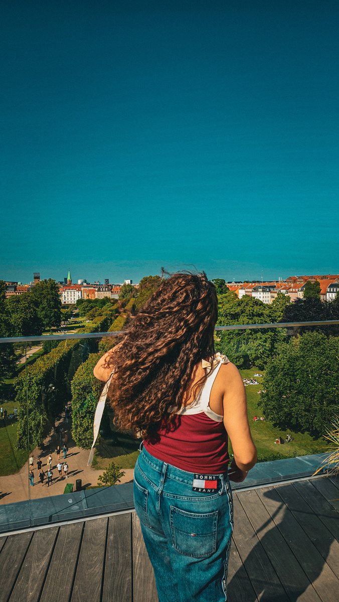 Espalda de una persona mirando hacia una ciudad desde una terraza
